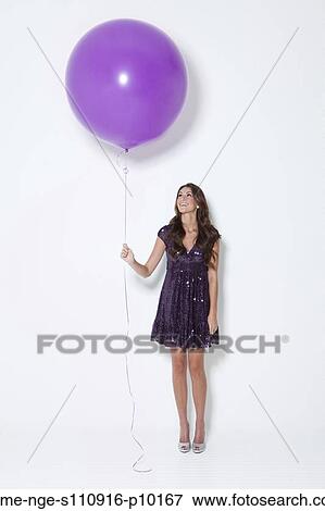 Young woman holding large balloon at party View Large Photo Image Stock Photo - Young woman holding large balloon at party. Fotosearch