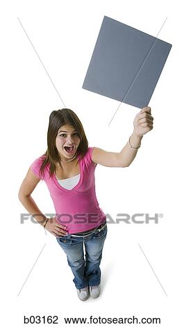 Stock Image - High angle view of a teenage girl holding a blank sign. Fotosearch