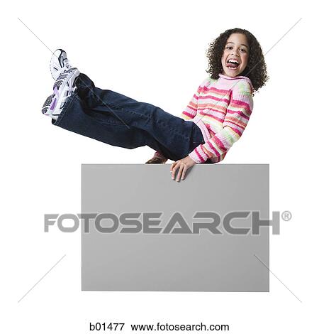 Portrait of a girl sticking her tongue out and sitting on a blank sign View Large Photo Image Stock Photo - Portrait of a girl sticking her tongue out and sitting on a blank sign. Fotosearch