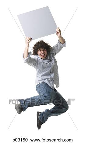 Portrait of a teenage boy holding a blank sign and jumping in mid-air View Large Photo Image Stock Image - Portrait of a teenage boy holding a blank sign and jumping in mid-air. Fotosearch