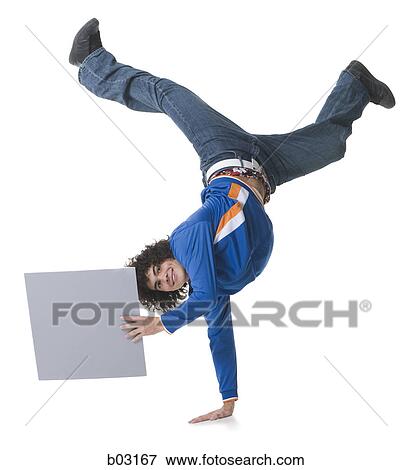 Stock Photo - Portrait of a teenage boy holding a blank sign and doing handstand. Fotosearch