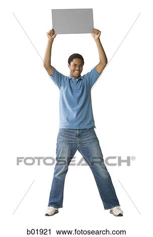 Portrait of a teenage boy holding up a blank sign View Large Photo Image Stock Image - Portrait of a teenage boy holding up a blank sign. Fotosearch