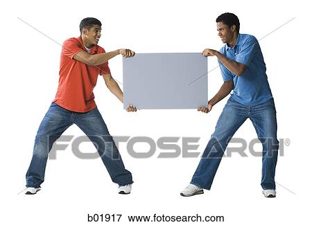 Stock Photo - Two young men fighting over a blank sign. Fotosearch