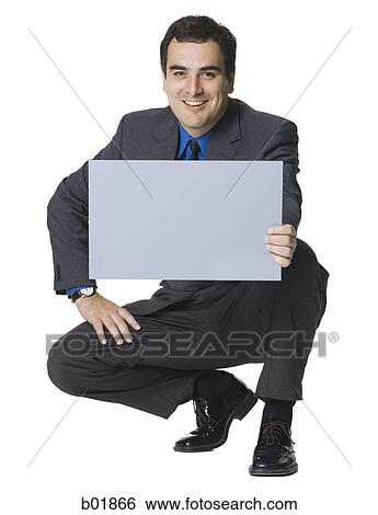 Stock Photograph - Businessman holding a blank sign. Fotosearch