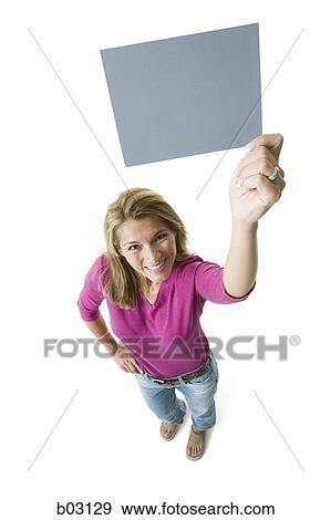 High angle view of a mid adult woman holding a blank sign View Large Photo Image Stock Photo - High angle view of a mid adult woman holding a blank sign. Fotosearch