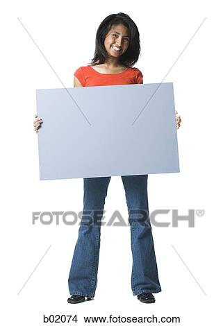 Portrait of a young woman holding a blank sign View Large Photo Image Picture - Portrait of a young woman holding a blank sign. Fotosearch