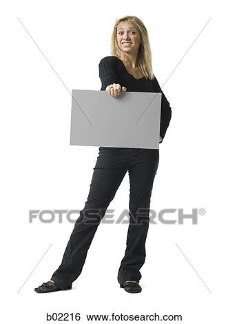 Stock Photograph - Portrait of a young woman holding a blank sign. Fotosearch