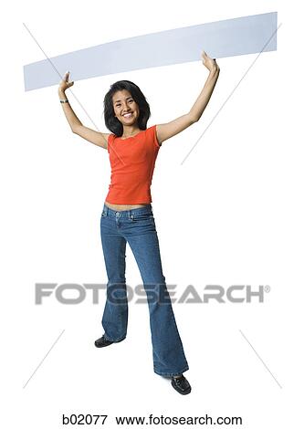 Portrait of a young woman holding up a blank sign View Large Photo Image Stock Photo - Portrait of a young woman holding up a blank sign. Fotosearch