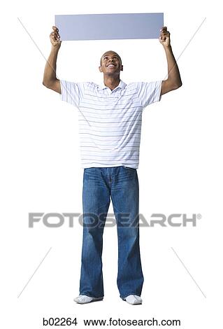 Picture - Young man holding up a blank sign. Fotosearch