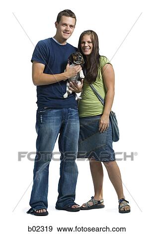 Stock Photo - Portrait of a young couple with a puppy. Fotosearch