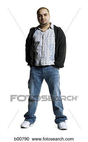 Stock Image - Portrait of a young man standing with his hands in his pockets. Fotosearch