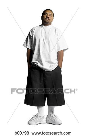 Portrait of a young man standing with his hands in his pockets View Large Photo Image Stock Photo - Portrait of a young man standing with his hands in his pockets. Fotosearch