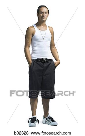 Portrait of a young man standing with his hands in pocket View Large Photo Image Stock Photo - Portrait of a young man standing with his hands in pocket. Fotosearch