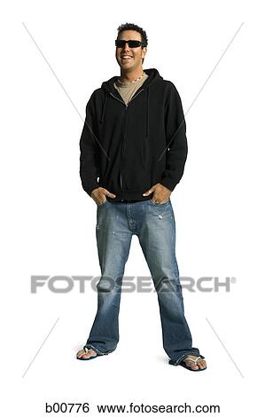 Young man standing with his hands in his pockets and smiling View Large Photo Image Stock Photograph - Young man standing with his hands in his pockets and smiling. Fotosearch