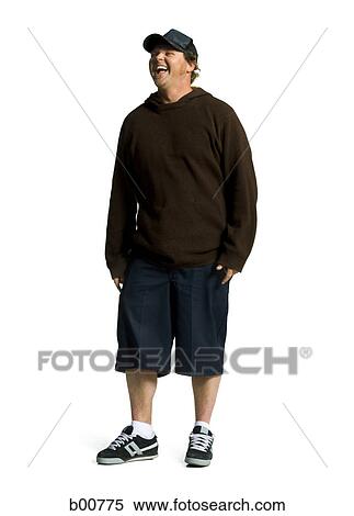 Stock Photography - Young man standing with his hands in his pockets. Fotosearch