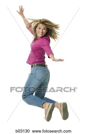 Stock Image - Portrait of a mid adult woman jumping in mid-air. Fotosearch