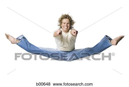 Stock Photo - Portrait of a young man jumping and pointing. Fotosearch
