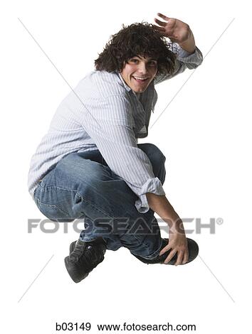 Side view of a teenage boy waving and jumping in mid-air View Large Photo Image Stock Photo - Side view of a teenage boy waving and jumping in mid-air. Fotosearch