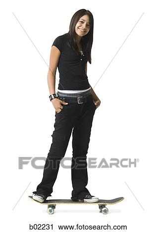 Portrait of a young woman standing on a skateboard View Large Photo Image Stock Image - Portrait of a young woman standing on a skateboard. Fotosearch