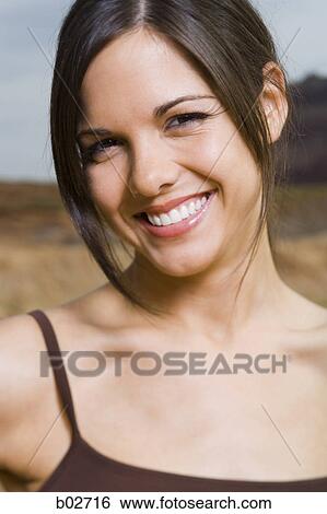 Close-up of a young woman smiling View Large Photo Image Stock Photograph - Close-up of a young woman smiling. Fotosearch