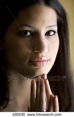 Portrait of a young woman with her hand on her chin View Large Photo Image Stock Image - Portrait of a young woman with her hand on her chin. Fotosearch