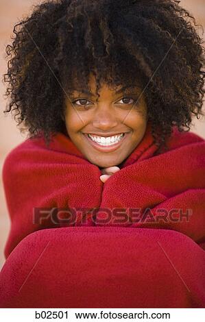 Portrait of a young woman wrapped in a blanket, smiling View Large Photo Image Stock Image - Portrait of a young woman wrapped in a blanket, smiling. Fotosearch