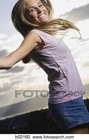 Portrait of a young woman smiling and jumping View Large Photo Image Stock Image - Portrait of a young woman smiling and jumping. Fotosearch