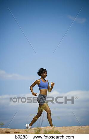 Profile of a young woman jogging View Large Photo Image Stock Image - Profile of a young woman jogging. Fotosearch