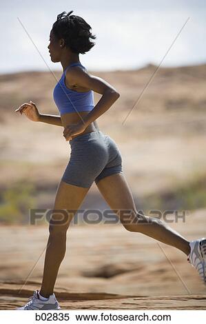 Stock Photography - Profile of a young woman jogging. Fotosearch