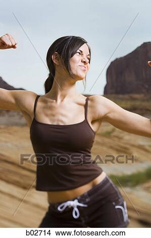 Picture - Young woman flexing her muscles. Fotosearch