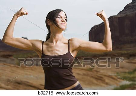 Young woman flexing her muscles View Large Photo Image Stock Photography - Young woman flexing her muscles. Fotosearch