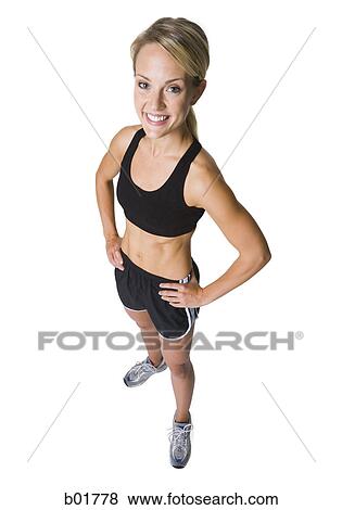 Stock Photo - High angle view of a young woman standing with her hands on her hips. Fotosearch