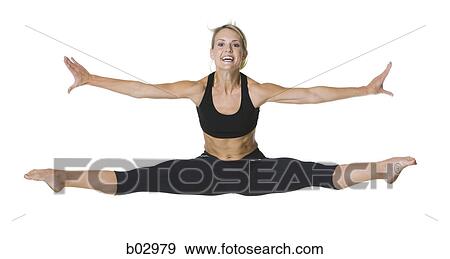 Stock Photo - Portrait of a young woman doing splits in mid-air. Fotosearch