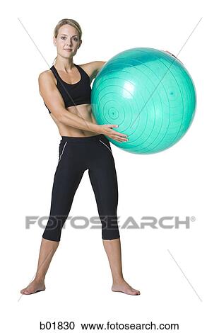 Portrait of a young woman holding a fitness ball View Large Photo Image Stock Image - Portrait of a young woman holding a fitness ball. Fotosearch
