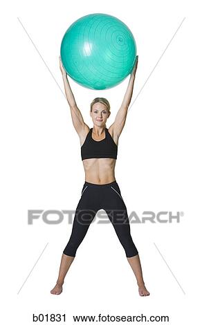 Portrait of a young woman holding a fitness ball View Large Photo Image Stock Image - Portrait of a young woman holding a fitness ball. Fotosearch