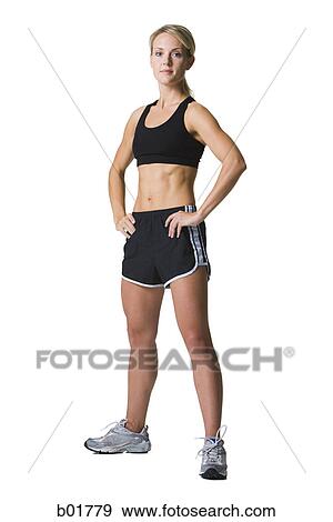 Stock Photo - Portrait of a young woman standing with her hands on hips. Fotosearch
