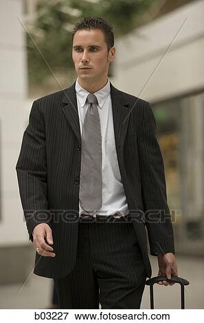 Businessman pulling his luggage View Large Photo Image Stock Photo - Businessman pulling his luggage. Fotosearch