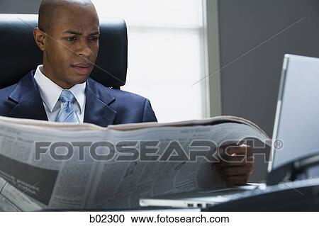 Businessman reading a newspaper View Large Photo Image Stock Image - Businessman reading a newspaper. Fotosearch