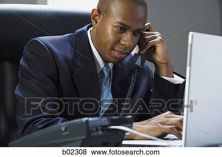 Stock Photo - Businessman working on a laptop computer. Fotosearch