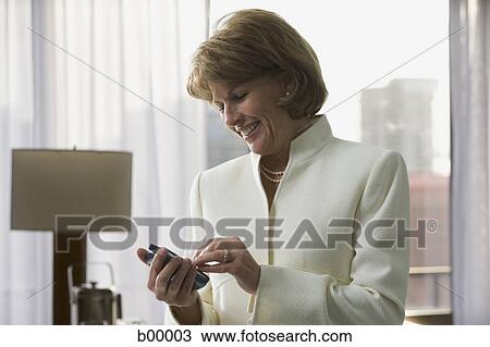 Businesswoman using a mobile phone View Large Photo Image Stock Image - Businesswoman using a mobile phone. Fotosearch
