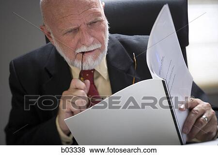 Stock Photo - Close-up of a businessman holding a file and eyeglasses. Fotosearch