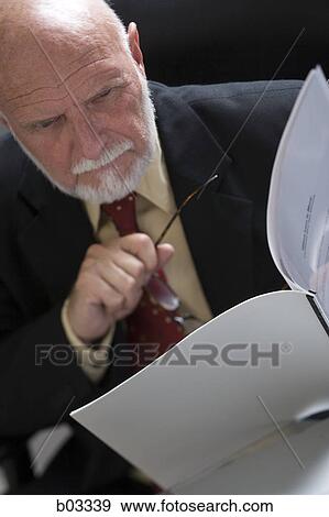 Close-up of a businessman holding a file and eyeglasses View Large Photo Image Stock Photo - Close-up of a businessman holding a file and eyeglasses. Fotosearch