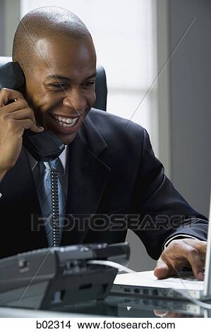 Close-up of a businessman smiling and talking on the phone View Large Photo Image Picture - Close-up of a businessman smiling and talking on the phone. Fotosearch