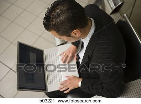 Stock Image - High angle view of a businessman using a laptop. Fotosearch