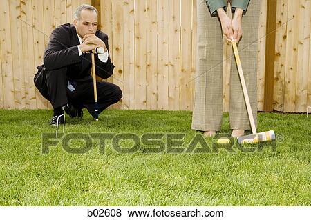 Businessman and a businesswoman playing croquet View Large Photo Image Stock Photo - Businessman and a businesswoman playing croquet. Fotosearch