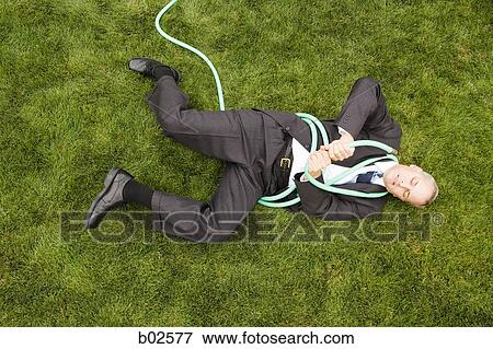 High angle view of a businessman playing with a hose View Large Photo Image Stock Photo - High angle view of a businessman playing with a hose. Fotosearch