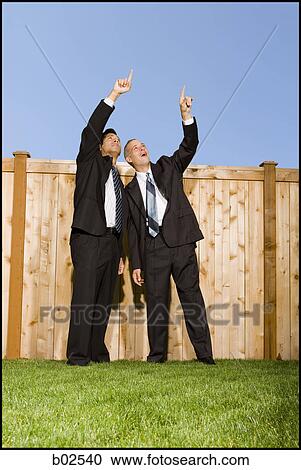 Low angle view of two businessmen pointing at the sky View Large Photo Image Stock Image - Low angle view of two businessmen pointing at the sky. Fotosearch