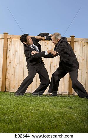 Profile of two businessmen playing and rough housing View Large Photo Image Picture - Profile of two businessmen playing and rough housing. Fotosearch