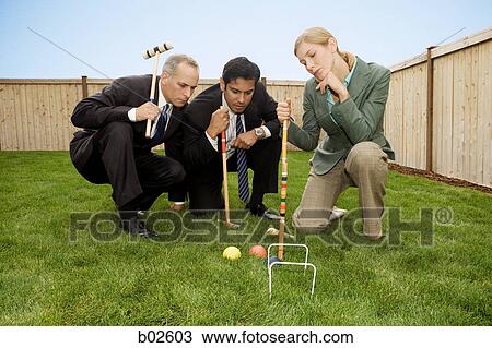 Two businessmen and a businesswoman playing croquet View Large Photo Image Stock Image - Two businessmen and a businesswoman playing croquet. Fotosearch