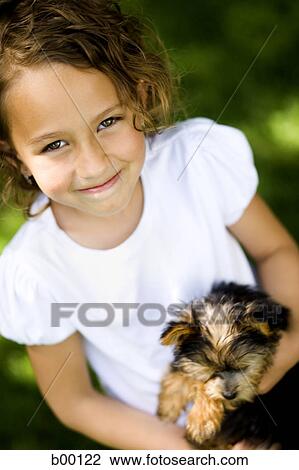 High angle view of a girl carrying a puppy View Large Photo Image Stock Image - High angle view of a girl carrying a puppy. Fotosearch